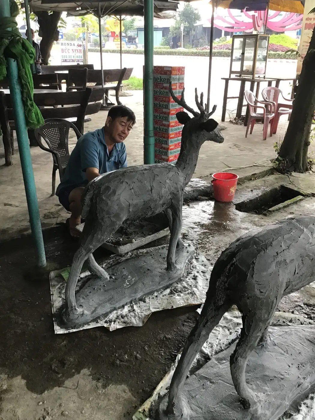 Nghệ nhân hoàn thiện tượng hươu xi măng thô tại xưởng, chuẩn bị công đoạn sơn