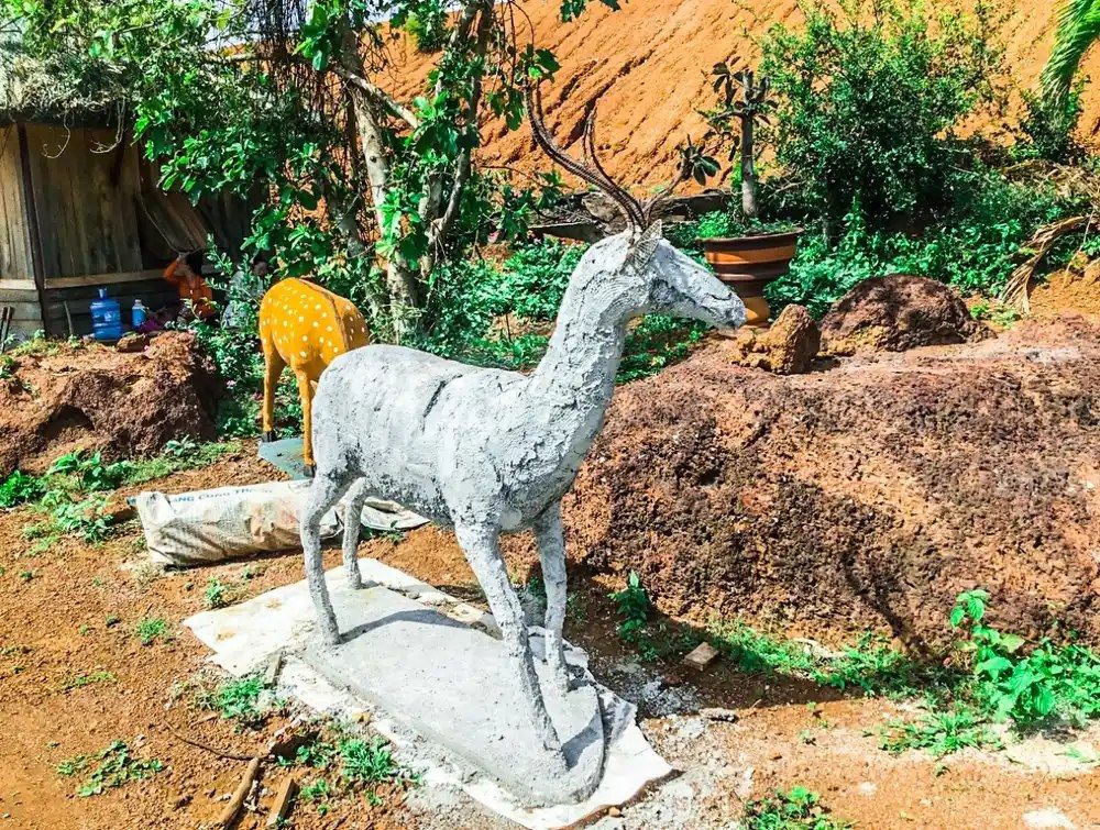 Nghệ nhân đắp cốt xi măng thô cho tượng hươu tại xưởng Bình An