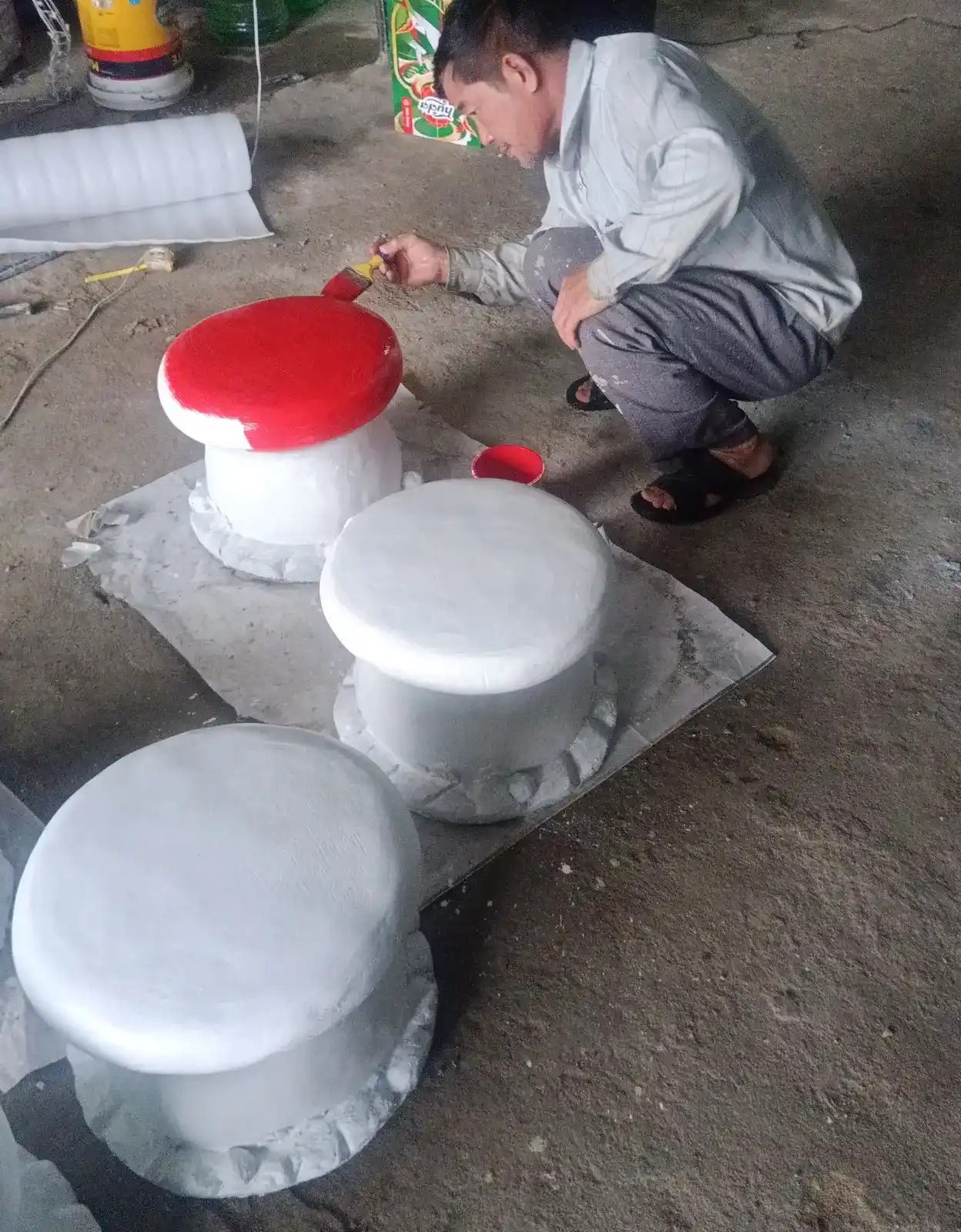 Người thợ tại xưởng Bình An tô chi tiết chấm bi trắng cho mũ nấm xi măng